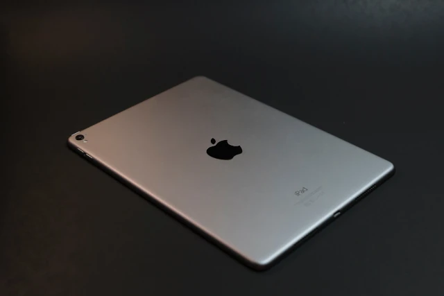 An Apple iPad, displaying the logo. 