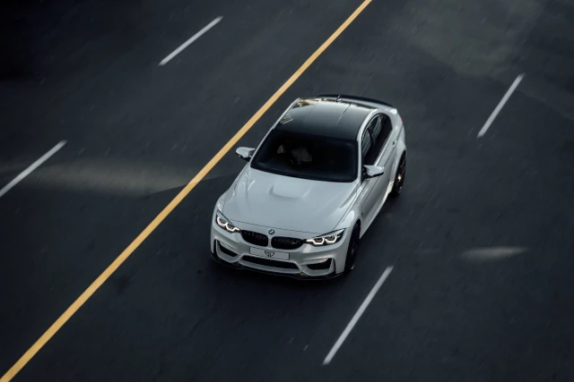 An overhead view of a BMW car driving on a road. 
