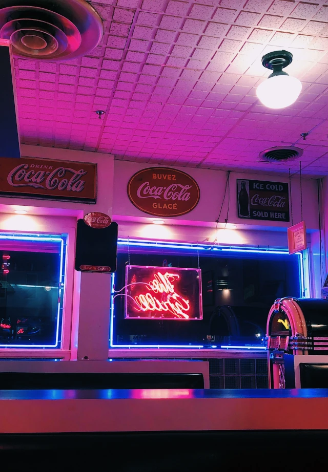 Coca Cola logos on signs in a bar. 