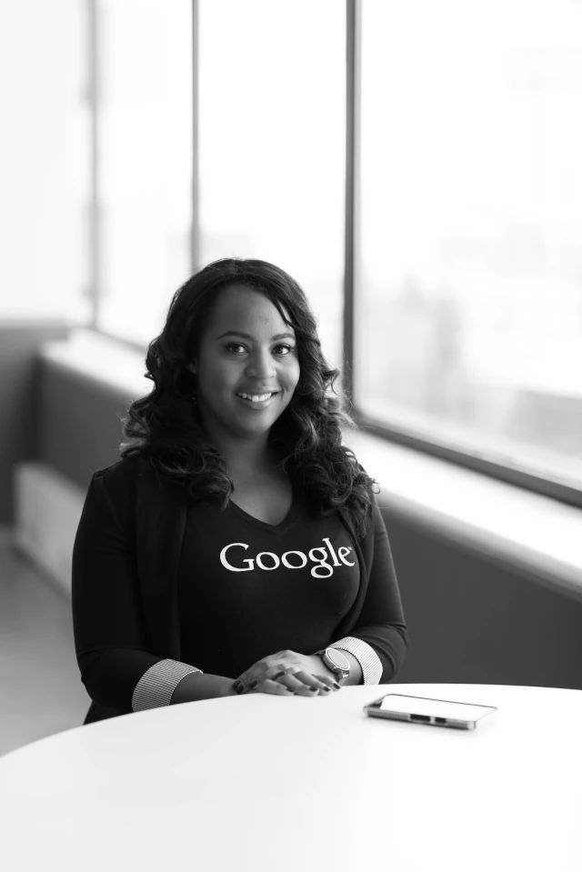 A businesswoman wearing a shirt with the Google logo on it. 
