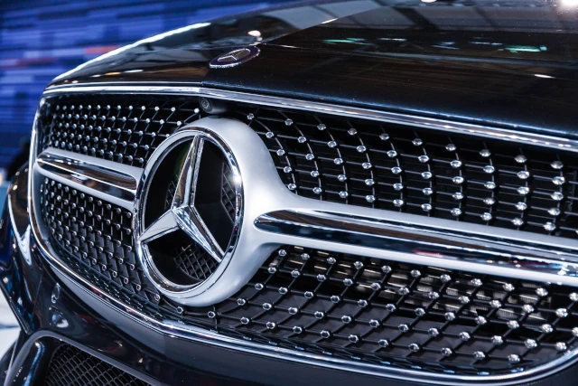 A Mercedes Benz badge on the hood of a car. 