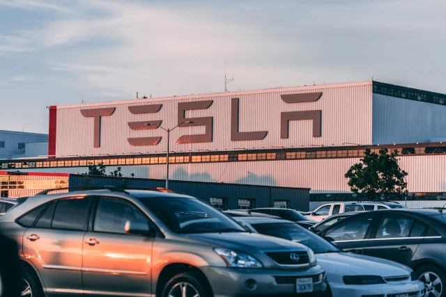 A Tesla showroom with the logo displayed on the wall. 